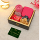 Gift box with pink items, a card, and decorative elements on a light background