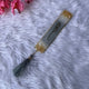 Decorative bookmark with tassel on a fluffy white surface with pink flowers.