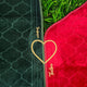 Green and red quilt with 'Taiba' branding on a grassy background