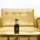 Adam - Luxury Ittar Perfume displayed on a gold table with a plush sofa, highlighting its premium appeal for wedding and bridal gifts.