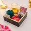 Gift set with candles, chocolates, and other items on a light background