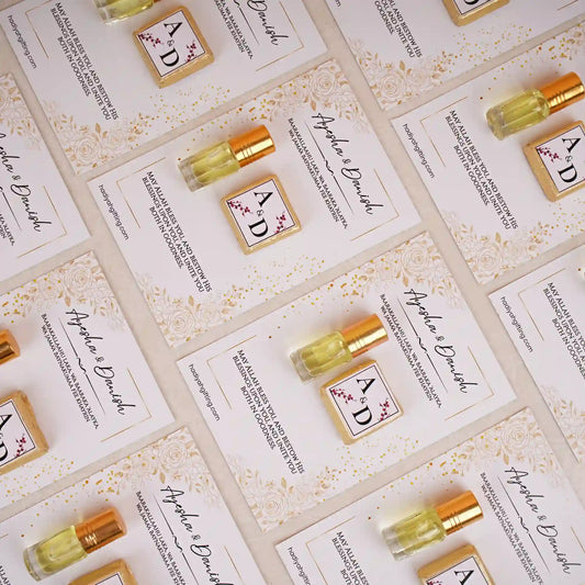 Premium Ittar & Chocolate Customised Card Favors for Nikah featuring gold-capped ittar bottles and monogrammed chocolates on floral cards.