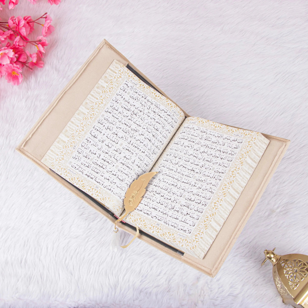 Kaaba Quran Premium displayed open with gold feather bookmark, surrounded by Islamic decor, ideal for gifting and prayer rituals.