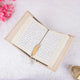 Open book with decorative cover on a light background with pink flowers