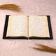 Open velvet Quran from the Black Sequence Rehal Hamper - Luxury Quran Gift Set, displayed on a soft fur surface with decorative grass accents.