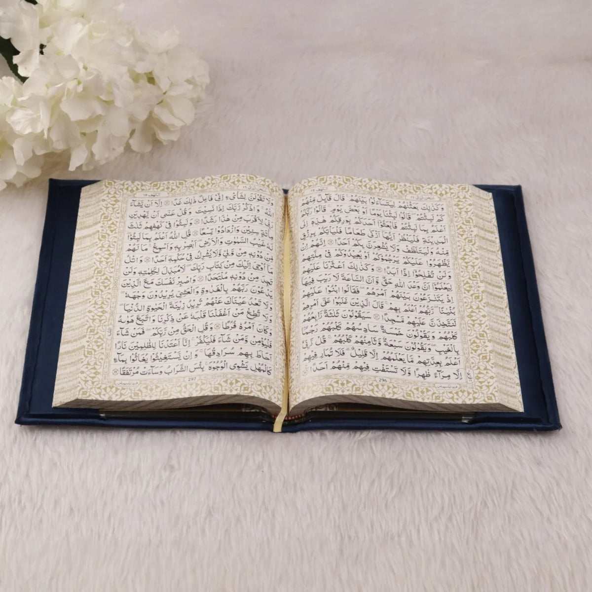 Open Quran with decorative gold borders from Blue Stones Rehal Hamper. Luxurious edition for gifting and personal use.