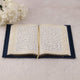 Open Quran with decorative gold borders from Blue Stones Rehal Hamper. Luxurious edition for gifting and personal use.