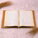 Open book with text on a light pink surface with decorative elements