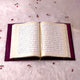 Open velvet Quran from the Purple Sequence Rehal Hamper set, displayed on white fur with decorative petals. Premium Quran gift set for women.