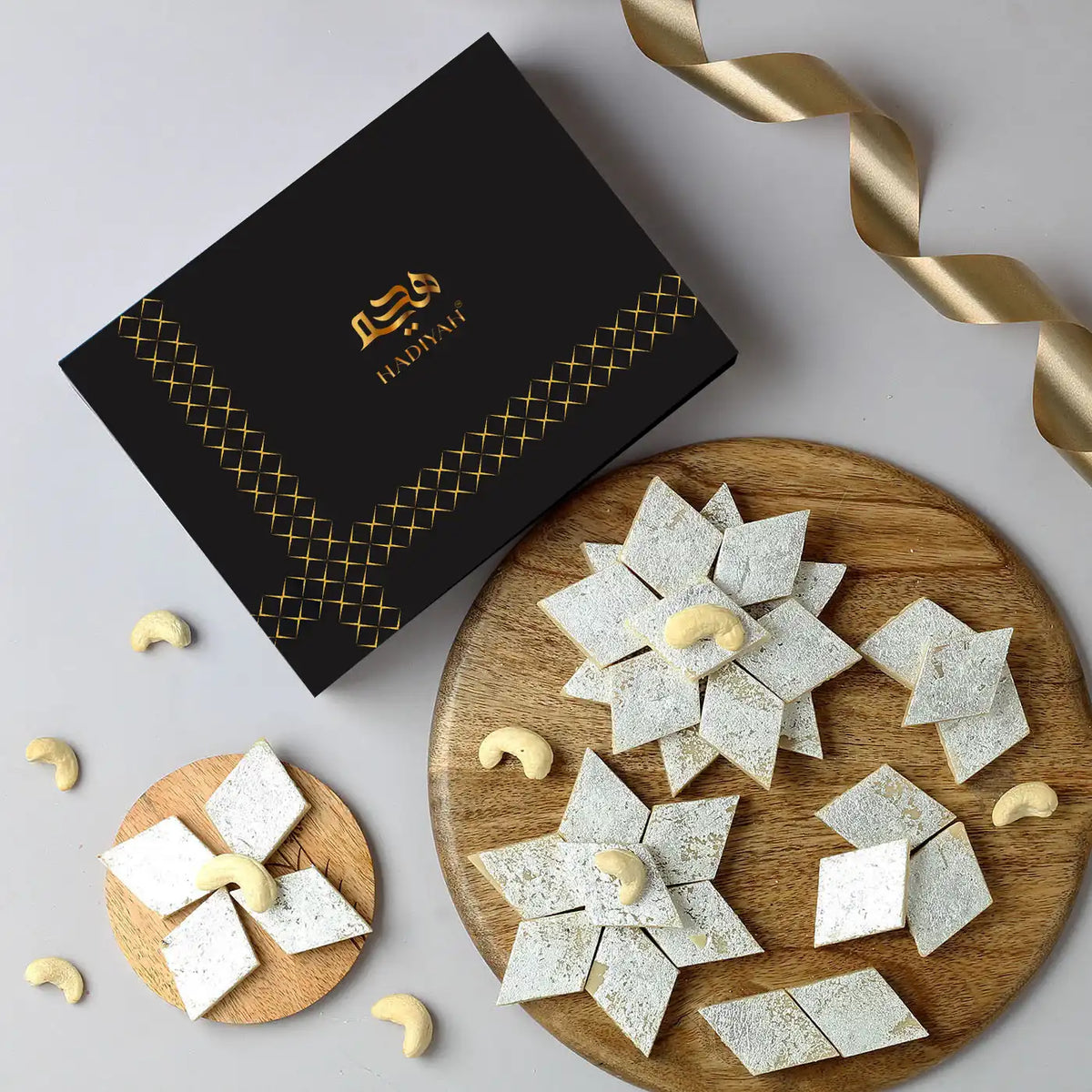 Premium Kaju Katli - Kaju Katli Online Buy | Pure Indian Sweets displayed with cashews and festive ribbon, ideal for gifting and celebrations.