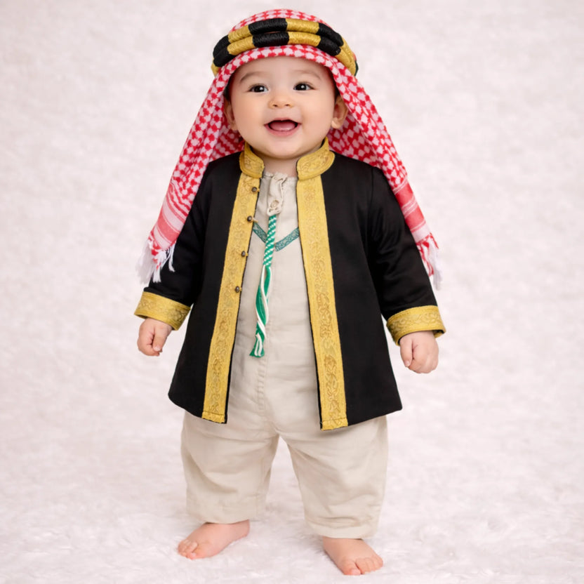 Baby boy wearing traditional black and gold embroidered thobe with red and white checkered headscarf Main image