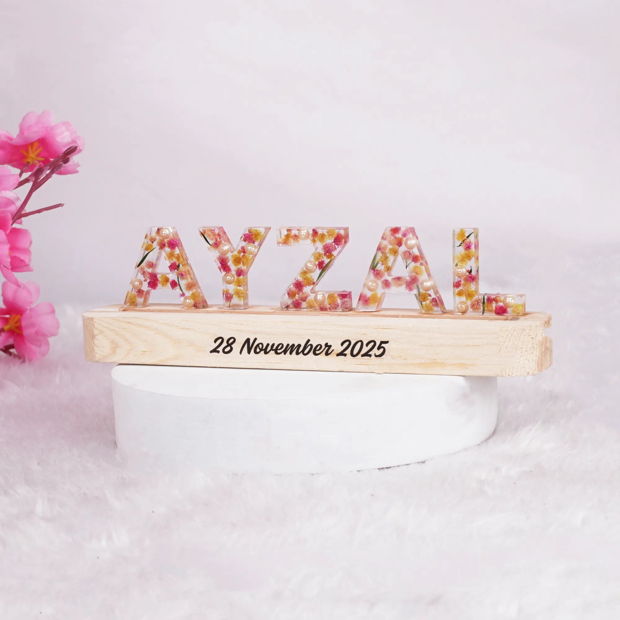 Personalized LED Name Stand with floral resin letters 'AYZAL' on a wooden base engraved with a date, ideal for gifting and kids' room decoration.
