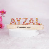 Personalized LED Name Stand with floral resin letters 'AYZAL' on a wooden base engraved with a date, ideal for gifting and kids' room decoration.