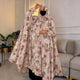 Person wearing a floral abaya in a living room setting
