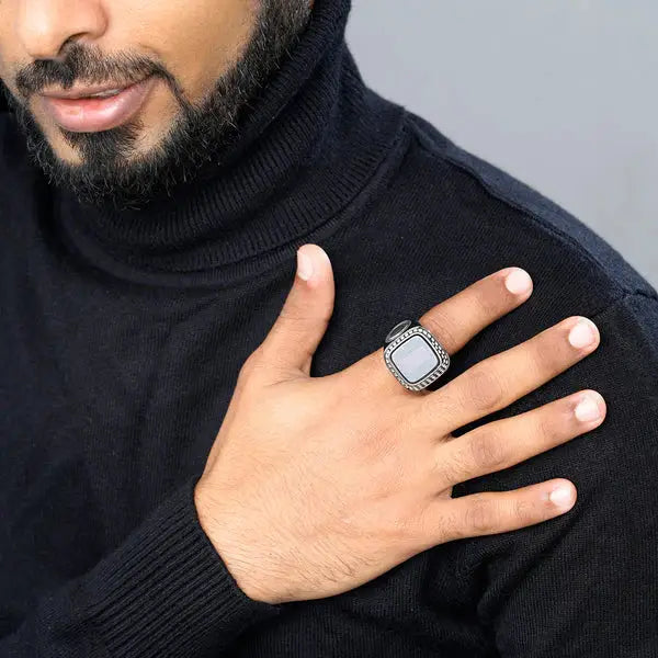 Man wearing Zikr Ring with 99 Zirconia on right hand, styled with black turtleneck. Stylish religious gift for men and prayer use.