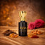 Mukhallat Oud - Luxury attar Perfume in a black and gold bottle with Arabic script, surrounded by oud, saffron, almonds, and roses on a golden fabric.