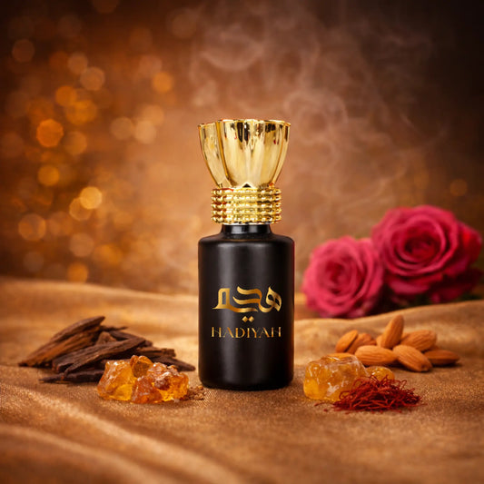 Mukhallat Oud - Luxury attar Perfume in a black and gold bottle with Arabic script, surrounded by oud, saffron, almonds, and roses on a golden fabric.