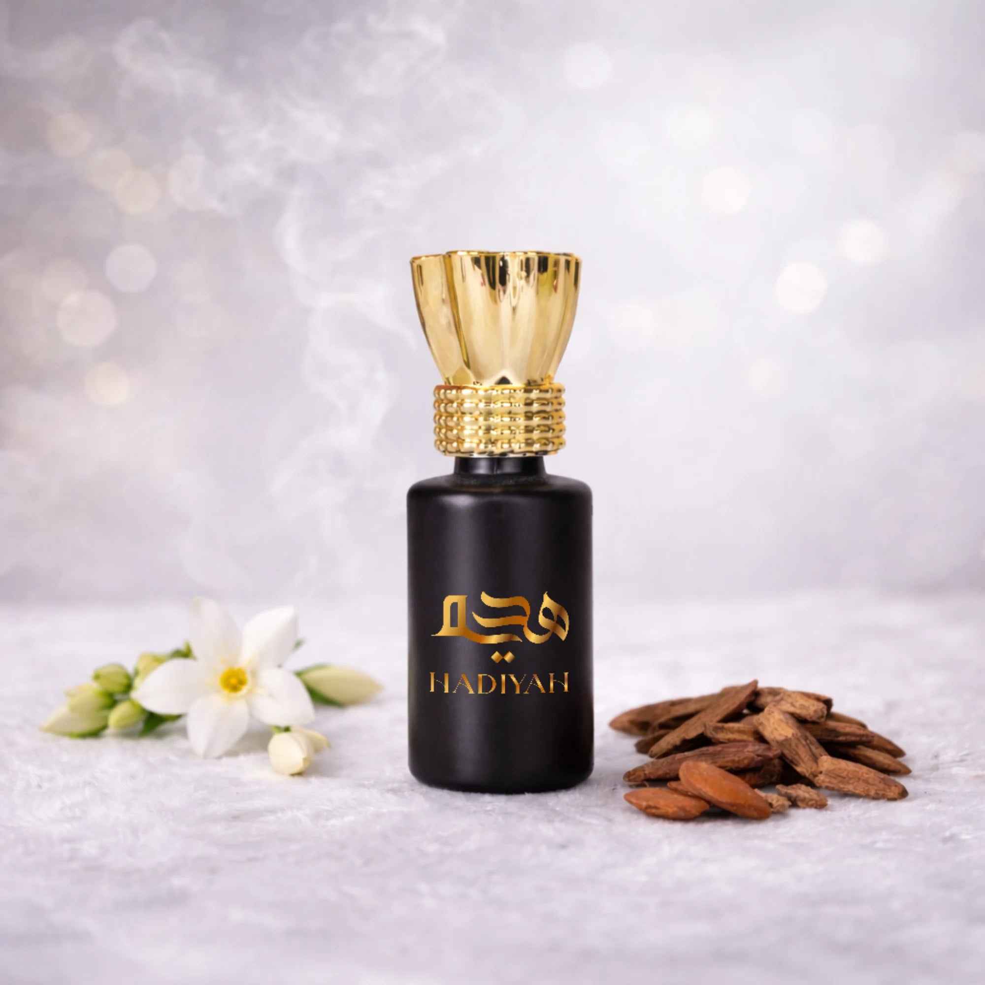 Musk Rijali - Luxury attar Perfume in a matte black bottle with gold cap, surrounded by jasmine flowers and oud wood chips. Alcohol-free fragrance ideal for Islamic gifting. Main image