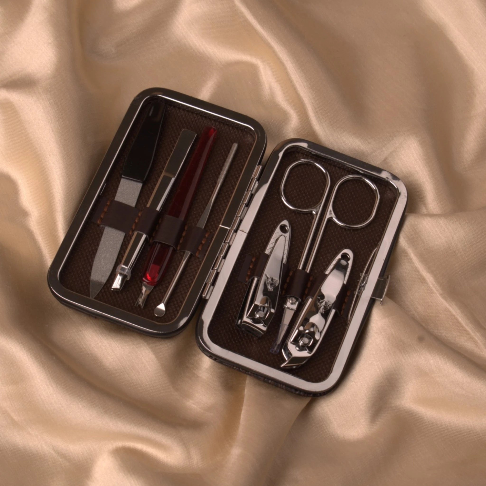 Luxury compact grooming kit with nail clippers, scissors, and tweezers in a brown leather case. Ideal for personal care during Hajj & Umrah.