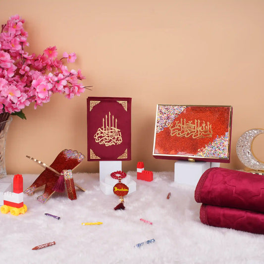 Maroon Kids Glitter Collection Ibadah Gift Set with Quran, tasbih, prayer mat, and decorative items on white fur. Ideal for Ramadan & Eid gifts.