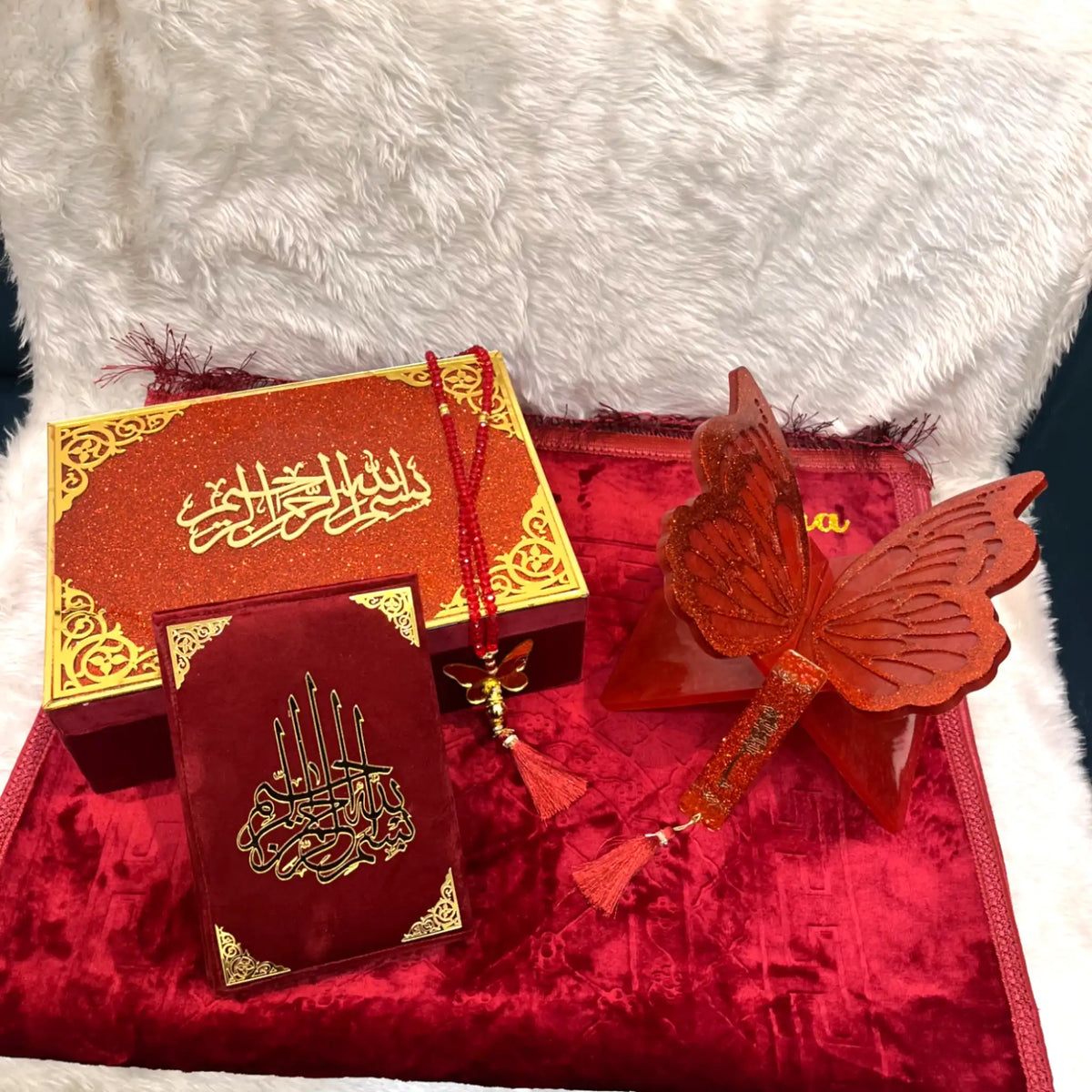 Decorative items including a red butterfly ornament and a small book with gold text on a white fur background.
