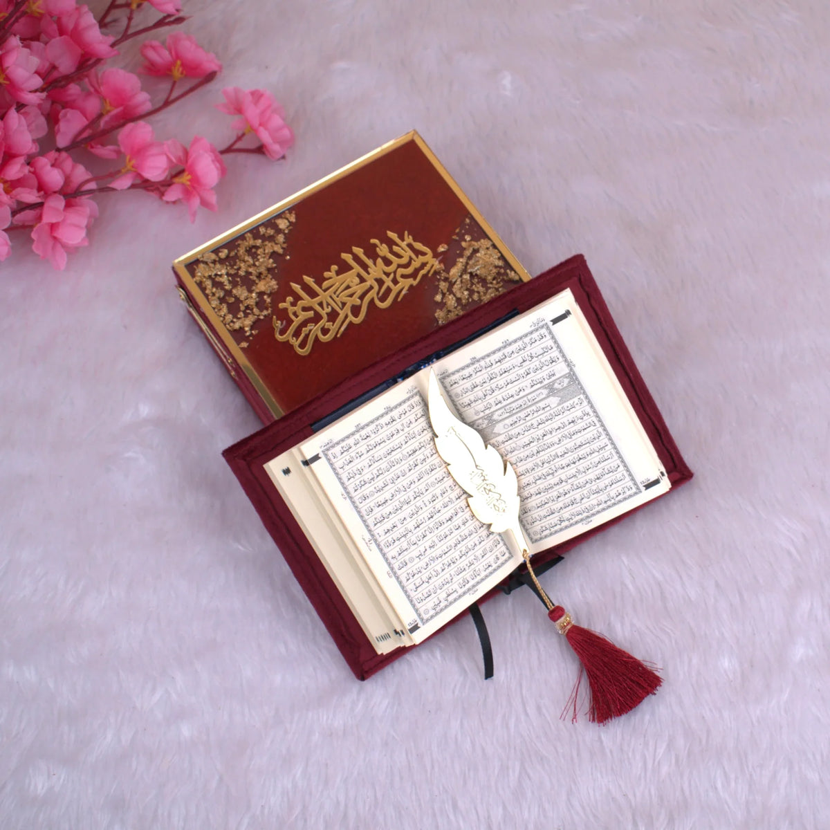 Open Mini Tilawat-e-Quran with Arabic script pages, maroon velvet cover, and gold feather bookmark, presented in a luxury gift box. Handmade in India.
