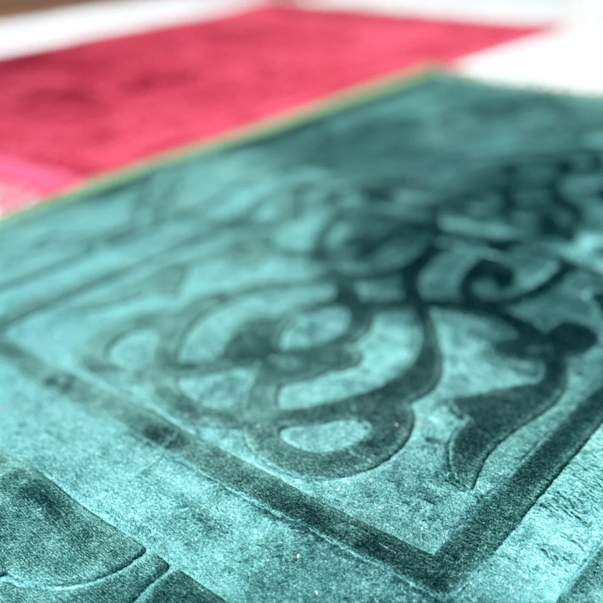 Close-up of green prayer mat from Maroon & Green Couple Prayer Mats Set, showcasing soft velvet texture and detailed Islamic patterns.