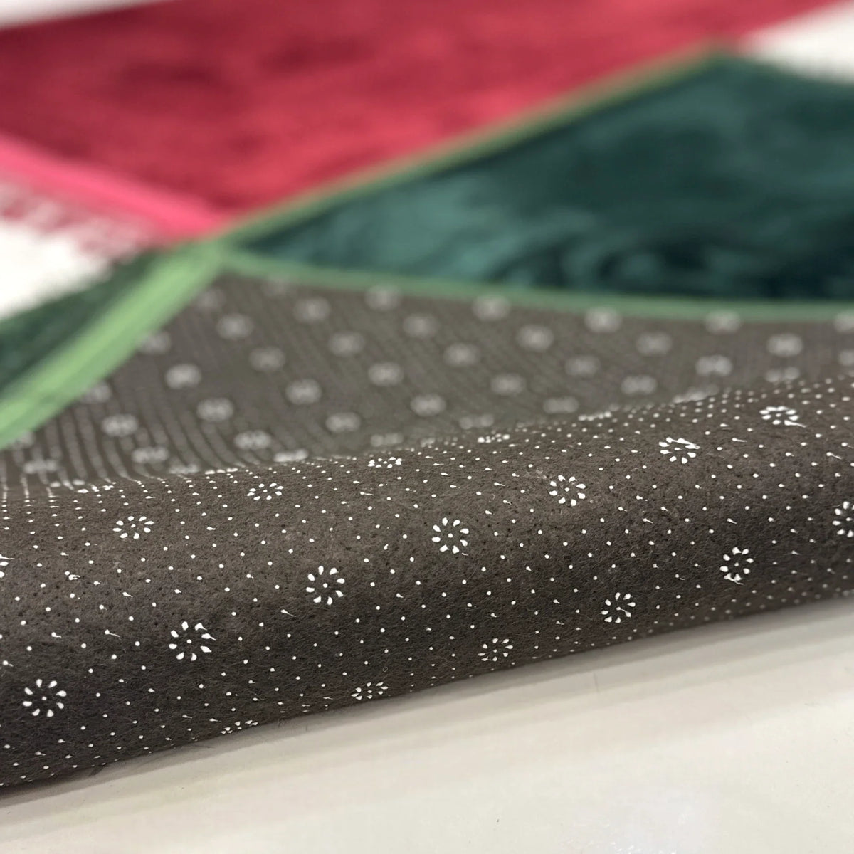 Non-slip backing of Maroon & Green Rectangle Couple Janamaz with dotted grip design, ensuring safe use during prayers on smooth surfaces.