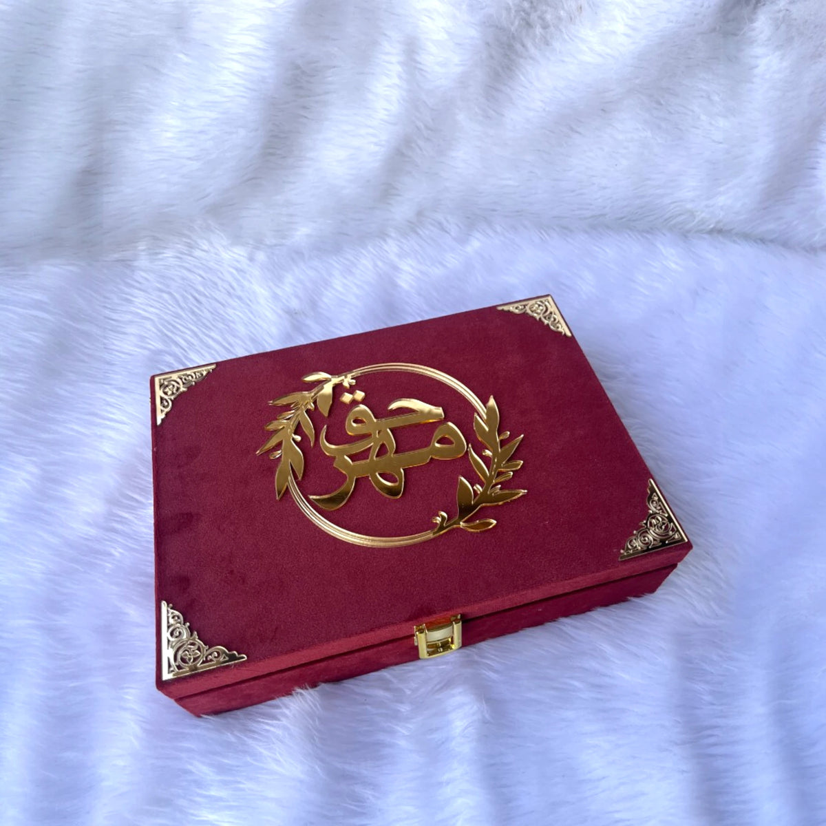 Closed Maroon Meher Bridal Box with gold Arabic calligraphy and ornate corner accents; elegant bridal gift packaging.