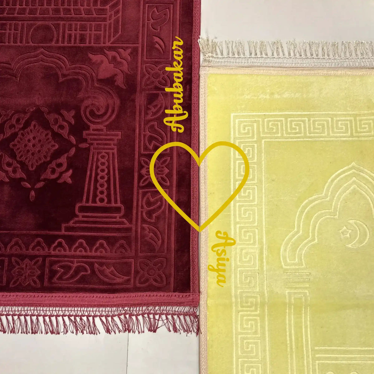 Two prayer mats, one red and one yellow with intricate patterns, on a white background.
