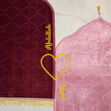Personalized Dome Couple Janamaz Set with names Abdullah and Ayesha, featuring maroon and pink prayer mats joined by a heart design.
