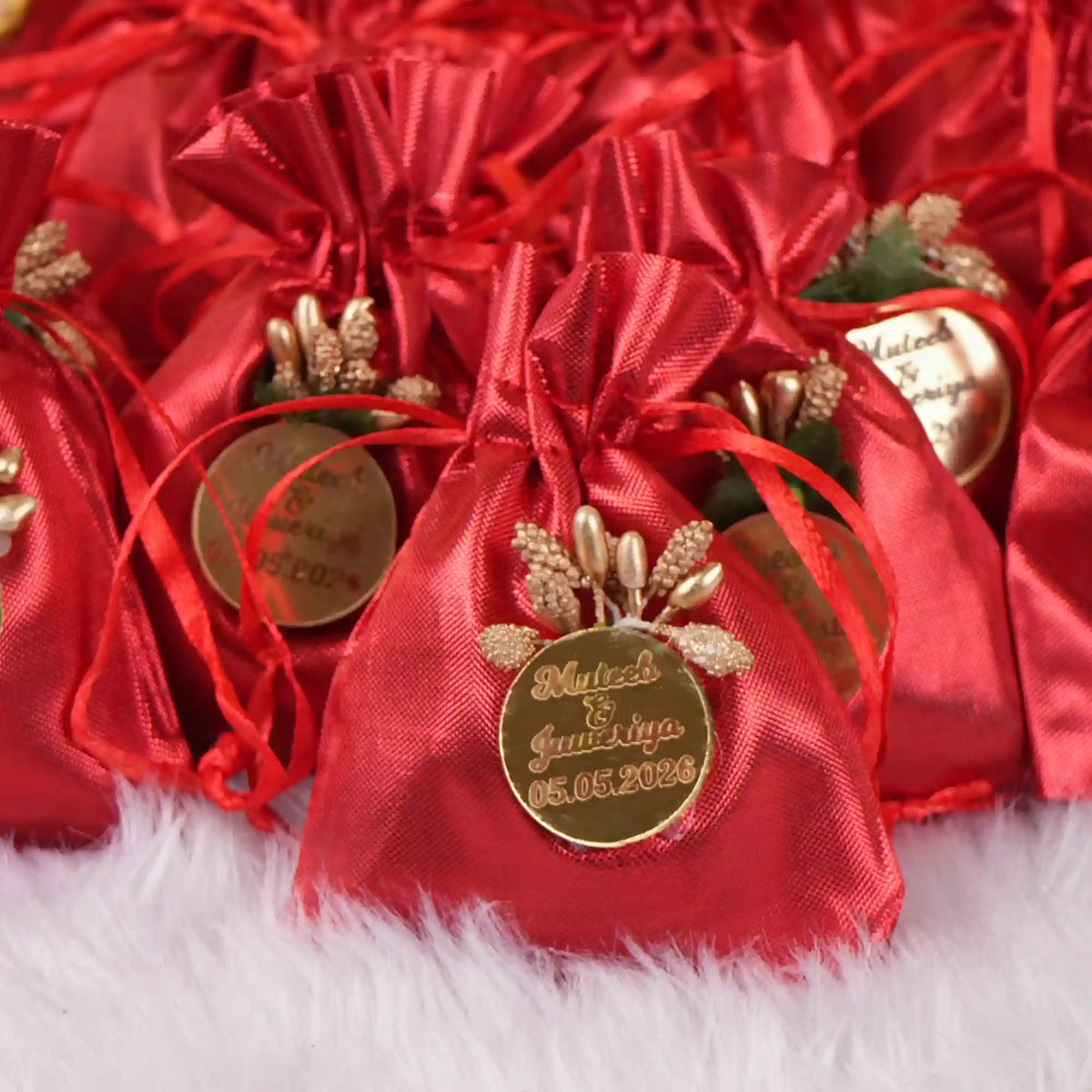 Red Nikah Favor Dry-Fruit Potlis with gold custom tags, handcrafted for elegant Muslim wedding gifts and party favors.