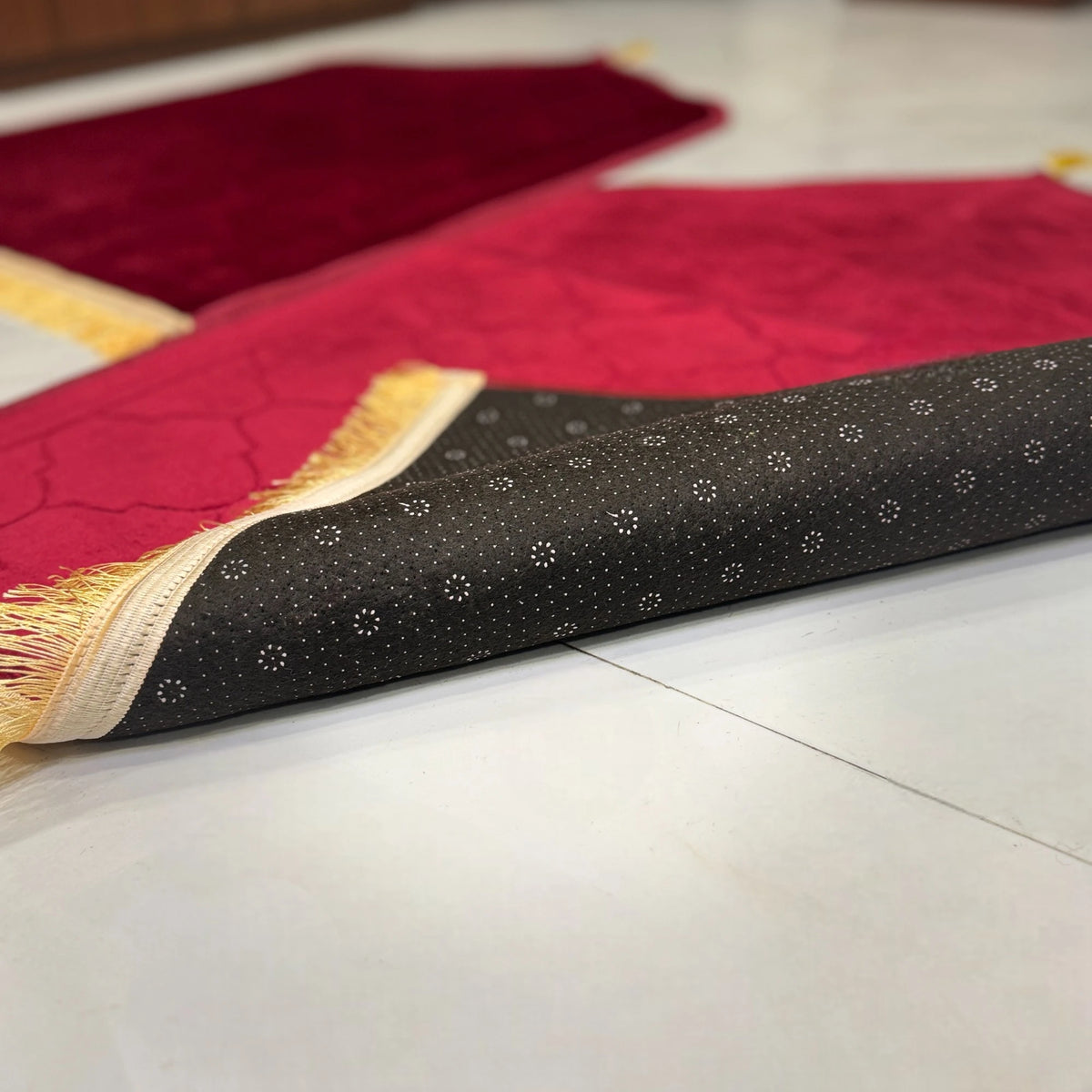 Backside of Maroon Dome Couple Janamaz showing anti-slip dotted base and golden fringe, combining elegance with functionality for daily prayer.