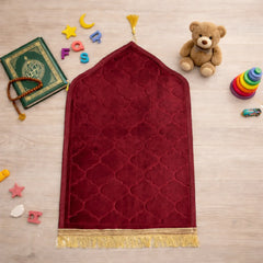 Maroon Kids Dome Janamaz - Kids Dome Prayer Rug surrounded by toys and Islamic items. Soft, foldable design perfect for children.