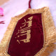 Close-up of elegant Mashallah Band featuring gold Arabic script and fringe on maroon velvet, perfect for wedding decor and Islamic blessings.