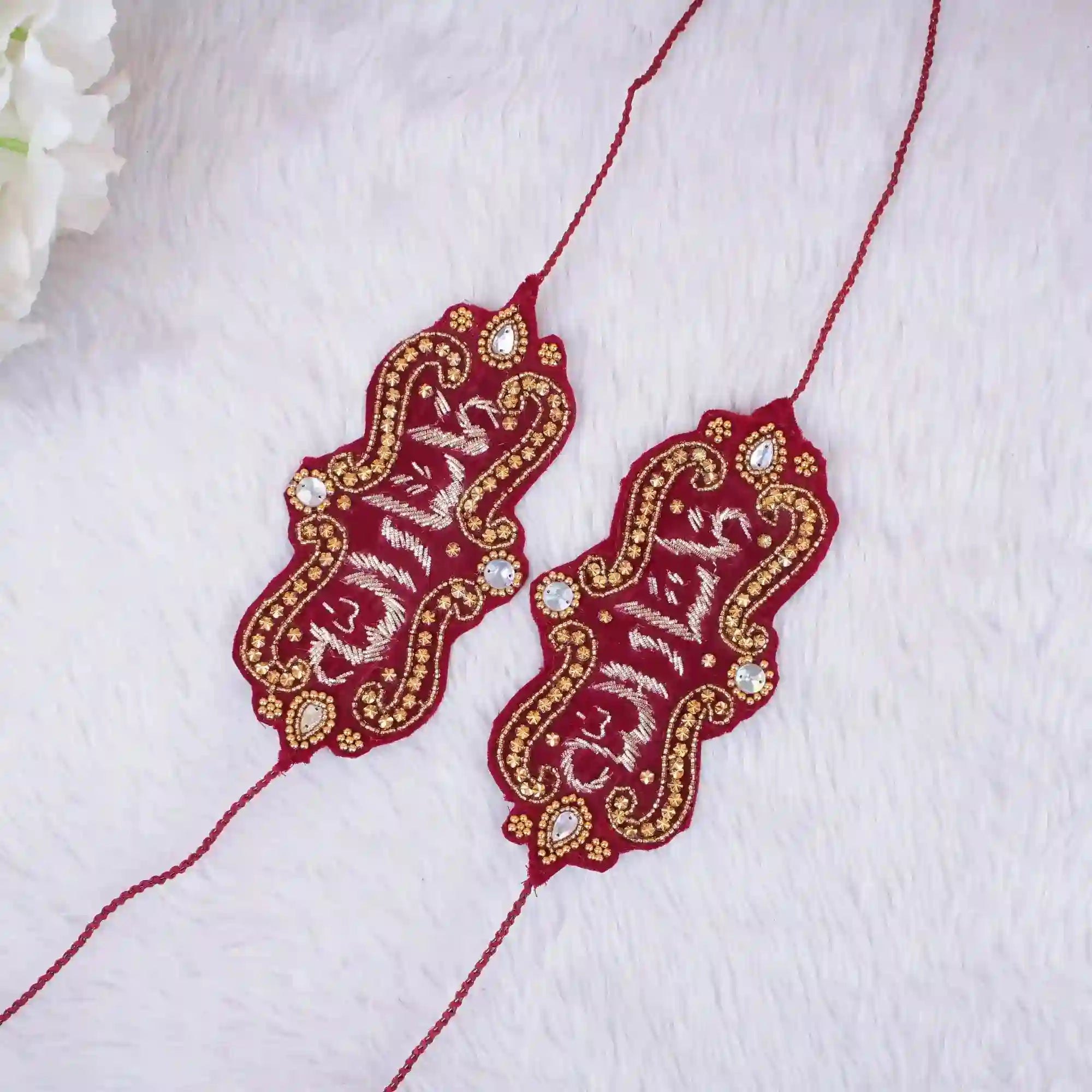 Decorative red and gold jewelry on a white fabric background Main image