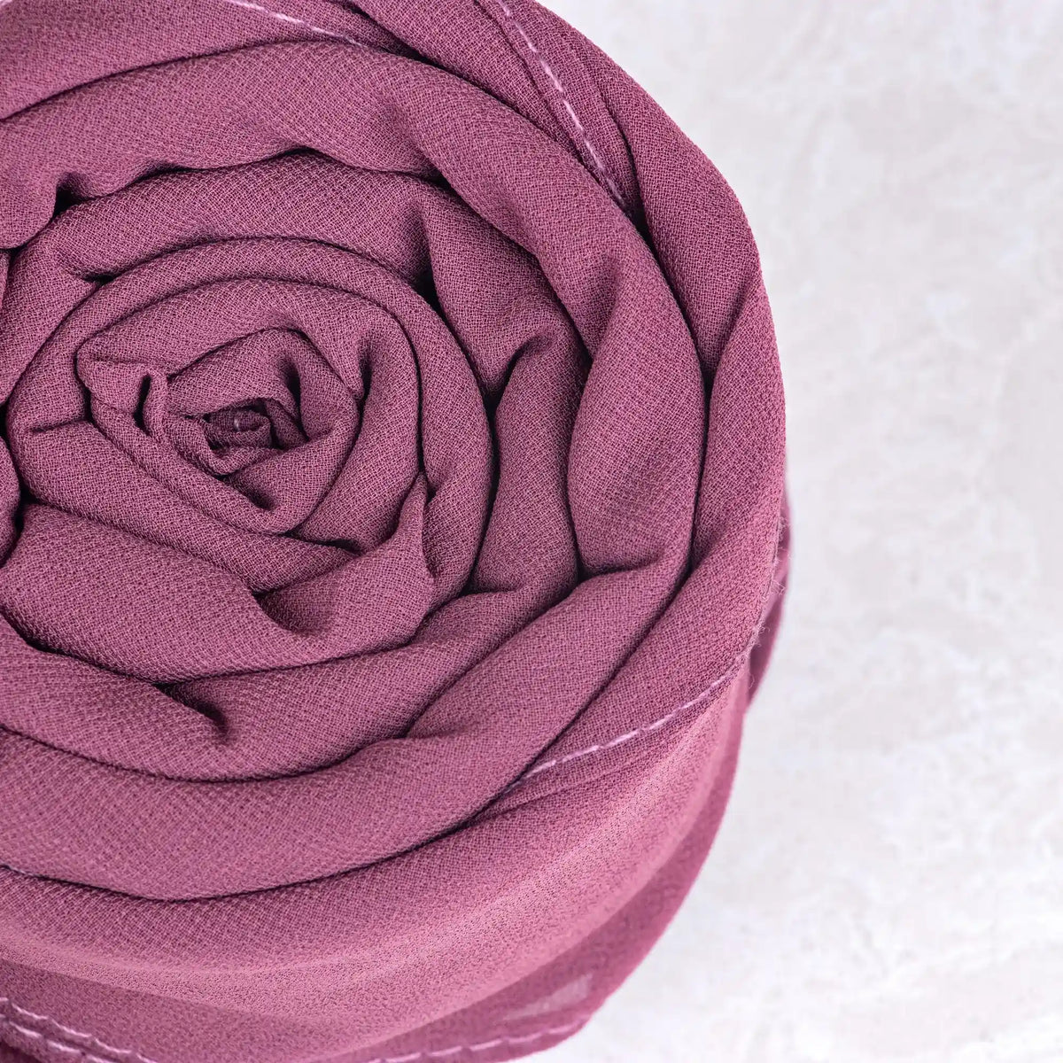 Rolled-up pink fabric on a white background