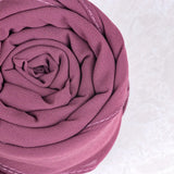 Rolled-up pink fabric on a white background