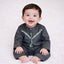 Baby boy smiling in black traditional outfit on white background