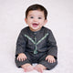 Baby boy smiling in black traditional outfit on white background