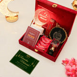 Gift set with Ramadan-themed items including a red box, cards, and a lamp on a light background.
