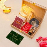 Gift set with Ramadan-themed items including a card, tea bags, and a lantern on a light background.