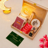 Gift set with Ramadan-themed items including a book, packets, and decorative plates on a light surface.