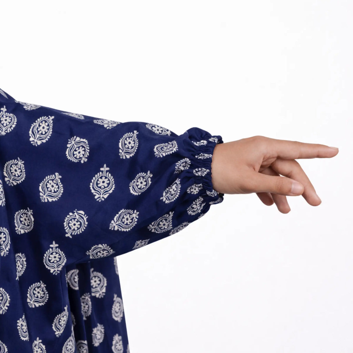 Navy blue garment with white floral patterns and a hand pointing.