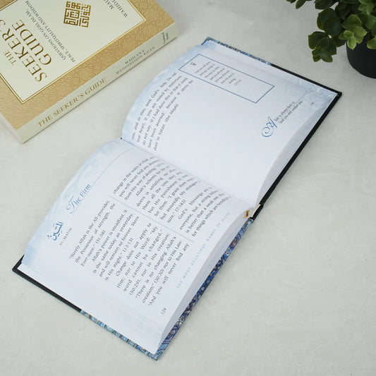 Open book with text on a light surface next to a closed book