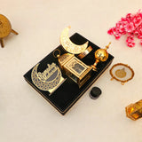Flat lay of Nazakat Luxury Ramadan Hamper with Islamic decor and moon lamp in a velvet tray, surrounded by festive pink flowers for Ramadan gifting.