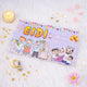 A single light purple Eidi gift envelope featuring the word 'EIDI' in bold yellow letters and cartoon illustrations of a Muslim family celebrating. The envelope is displayed on a soft white faux fur surface, styled with a lit tea light candle, scattered golden star confetti, a crescent moon charm, and a pink flower.