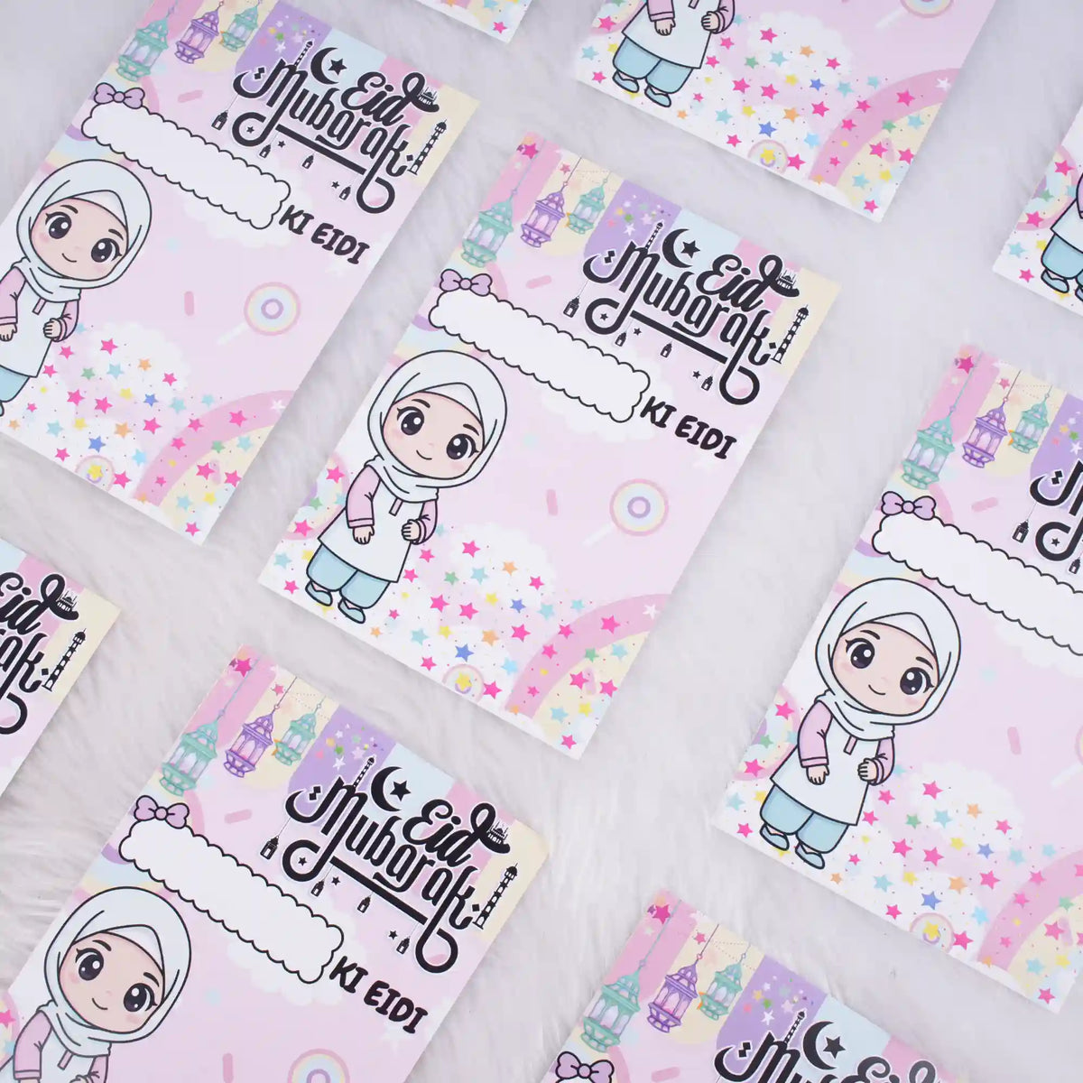 Multiple pink premium Eid Mubarak Eidi cards for girls scattered on a white fluffy background.