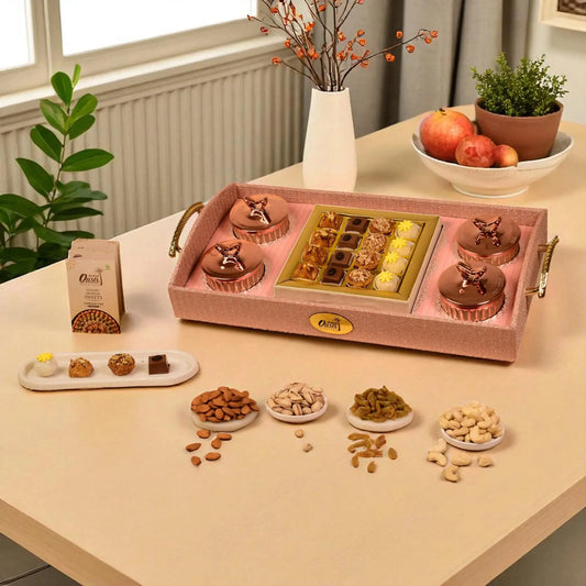 Decorative tray with confectionery and nuts on a table with plants and apples in the background