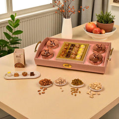 Decorative tray with confectionery and nuts on a table with plants and apples in the background
